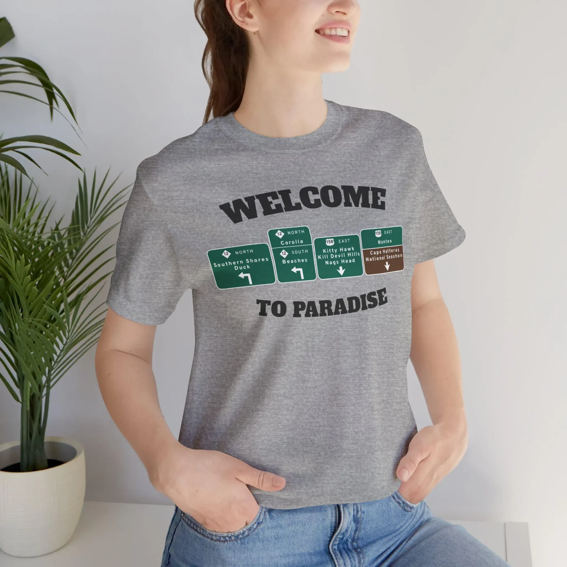 Grey heather t-shirt with WELCOME TO PARADISE lettering and green Outer Banks highway signs across the chest