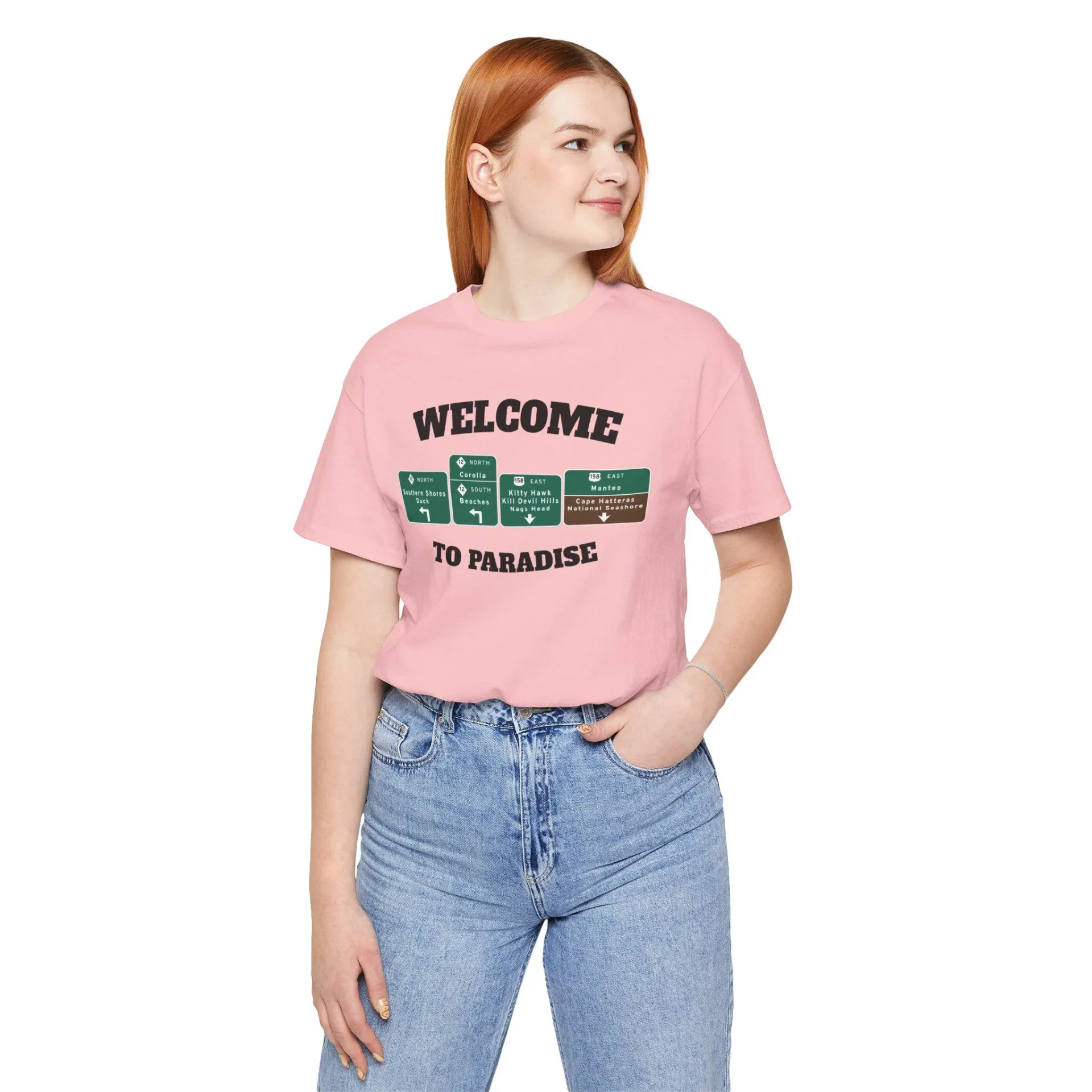 Pink t-shirt with WELCOME TO PARADISE lettering and green Outer Banks highway signs across the chest