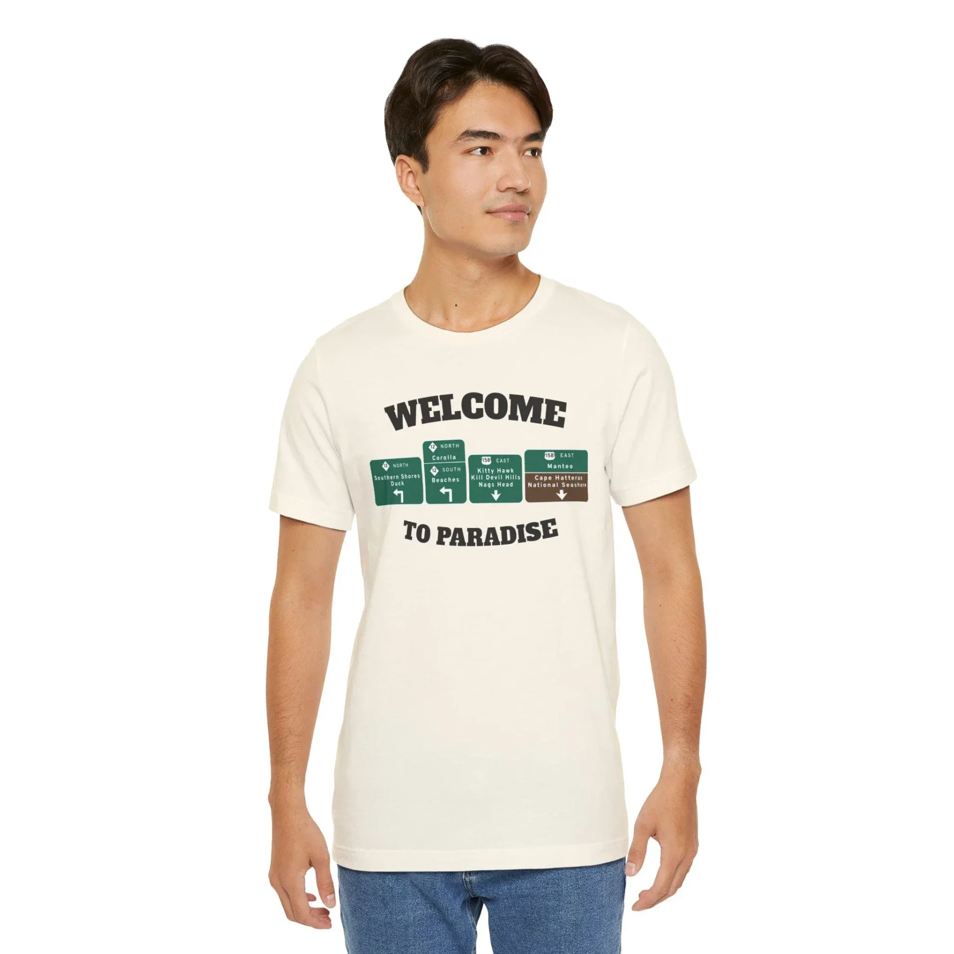 Cream natural t-shirt with WELCOME TO PARADISE lettering and green Outer Banks highway signs across the chest