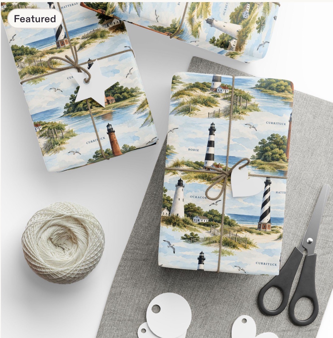 Gifts wrapped in watercolor Outer Banks lighthouse paper showing Currituck, Bodie, Hatteras and Ocracoke lighthouses among dunes, fences and seagulls